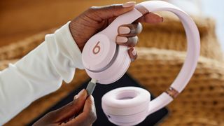 Beats Solo 4 headphones with a USB-C able being inserted into them