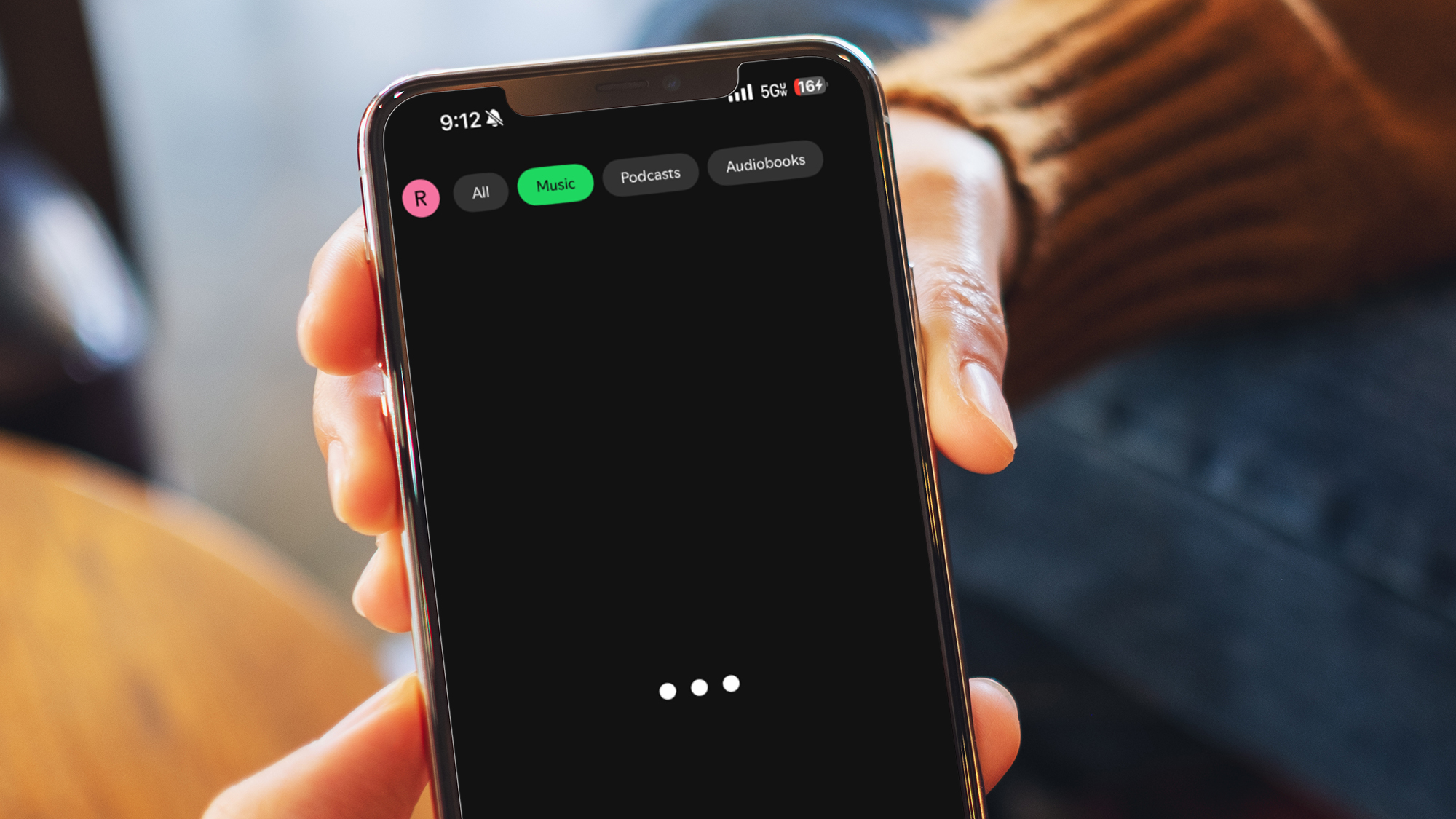 Two hands holding a phone showing the Spotify app being down
